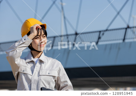 Woman in work clothes at a construction site 128951945