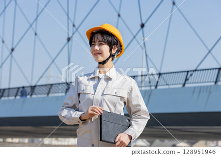 Woman in work clothes at a construction site 128951946