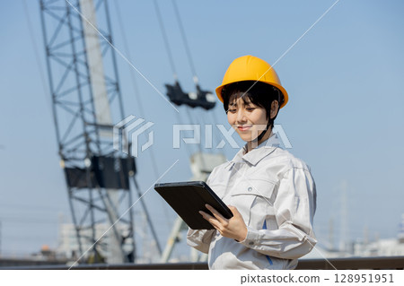Woman in work clothes at a construction site Woman in work clothes at a construction site 128951951