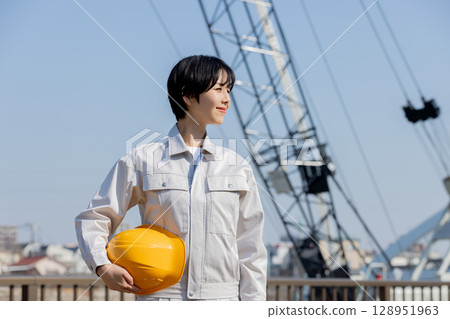 Woman in work clothes at a construction site 128951963