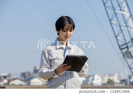 Woman in work clothes at a construction site 128951966