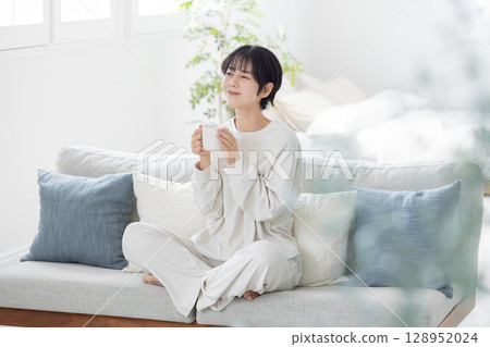 Woman drinking coffee on the sofa 128952024