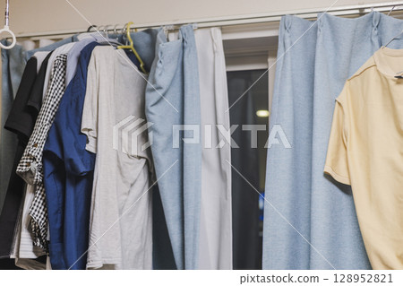Man living alone, drying laundry indoors Man living alone, drying laundry indoors 128952821