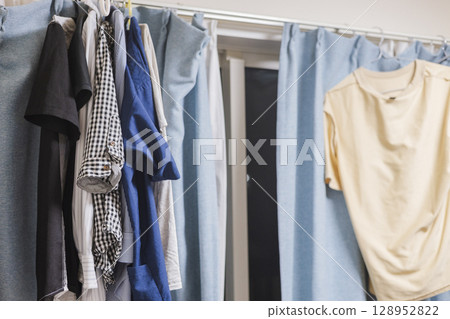 Man living alone, drying laundry indoors Man living alone, drying laundry indoors 128952822