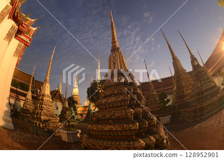 Scenic sunset time of Classic Thai architecture with pagoda in Wat Phra Chetuphon or Wat Pho. Which is one of the largest and oldest temples and is popular with both Thai and foreign tourists. Scenic sunset time of Classic Thai architecture with pagoda in Wat Phra Chetuphon or Wat Pho. Which is one of the largest and oldest temples and is popular with both Thai and foreign tourists. 128952901