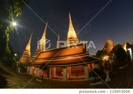 Scenic night time of Classic Thai architecture with pagoda in Wat Phra Chetuphon or Wat Pho. Which is one of the largest and oldest temples and is popular with both Thai and foreign tourists. Scenic night time of Classic Thai architecture with pagoda in Wat Phra Chetuphon or Wat Pho. Which is one of the largest and oldest temples and is popular with both Thai and foreign tourists. 128953009