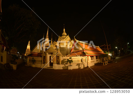 Scenic night time of Classic Thai architecture with pagoda in Wat Phra Chetuphon or Wat Pho. Which is one of the largest and oldest temples and is popular with both Thai and foreign tourists. 128953050