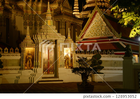 Scenic night time of Classic Thai architecture with pagoda in Wat Phra Chetuphon or Wat Pho. Which is one of the largest and oldest temples and is popular with both Thai and foreign tourists. 128953052