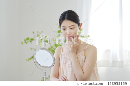 Beauty: Woman looking in the mirror and worrying at home Beauty: Woman looking in the mirror and worrying at home 128953169
