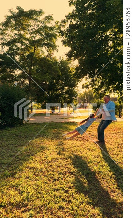 child father park, children game pilot sunset, kid flight, Father and daughter enjoying a sunny day in the park, Playful moments between a dad and his child, Spinning around and laughing together child father park, children game pilot sunset, kid flight, Father and daughter enjoying a sunny day in the park, Playful moments between a dad and his child, Spinning around and laughing together 128953263