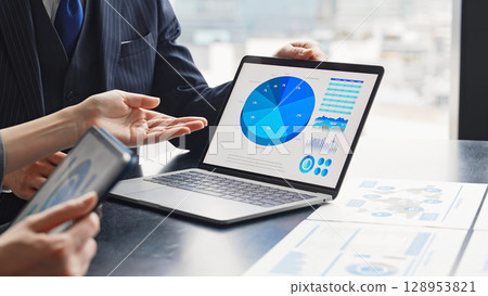 一群商務人士在辦公室開會，同時看著電腦螢幕 128953821