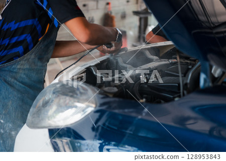 Checking car body work fiber bumper at car garage 128953843