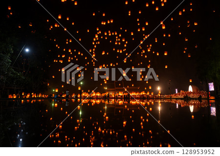 Fire Lanterns Floating up into the sky is reflection in the water at night at Loi Krathong Festival Travel Destinations Of Chiang Mai, Thailand. Fire Lanterns Floating up into the sky is reflection in the water at night at Loi Krathong Festival Travel Destinations Of Chiang Mai, Thailand. 128953952