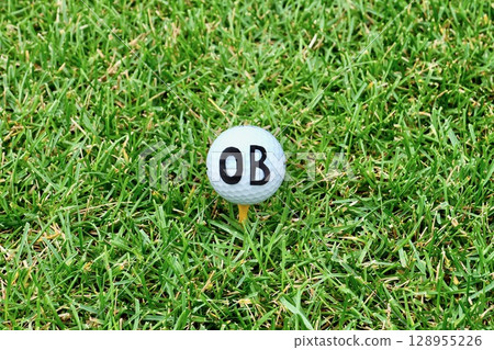 草地上放置著一顆印有「OB」字母的白色高爾夫球 128955226