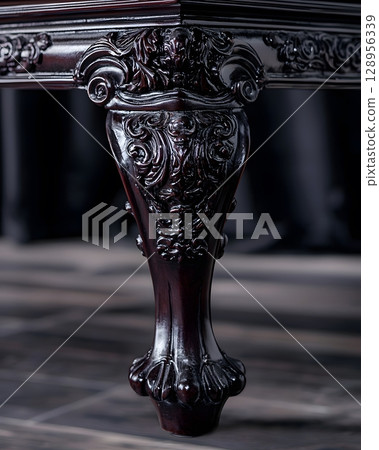 Black table with a carved leg and a black background 128956339