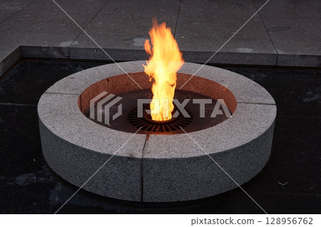 An Eternal Flame beautifully placed in a Stone Basin, set against a serene backdrop at Dusk An Eternal Flame beautifully placed in a Stone Basin, set against a serene backdrop at Dusk 128956762