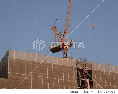HighRise Construction Utilizing a Crane Actively Engaged in Work and Operations 128957094