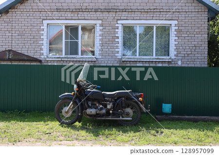 A classic motorcycle parked by a rustic house, capturing nostalgia and adventure A classic motorcycle parked by a rustic house, capturing nostalgia and adventure 128957099