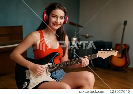 AI generated image of a young woman with a bright smile playing an electric guitar in a music rehearsal studio. She is dressed casually exudes creativity confidence surrounded by musical instruments. AI generated image of a young woman with a bright smile playing an electric guitar in a music rehearsal studio. She is dressed casually exudes creativity confidence surrounded by musical instruments. 128957640