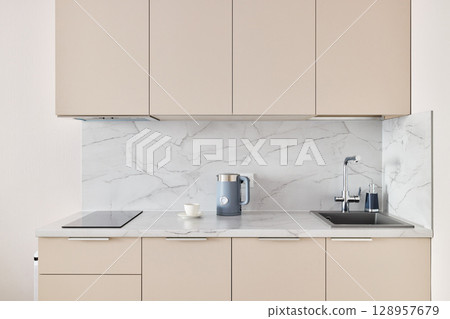 This modern minimalist kitchen has a marble backsplash and neutral cabinets for elegance This modern minimalist kitchen has a marble backsplash and neutral cabinets for elegance 128957679
