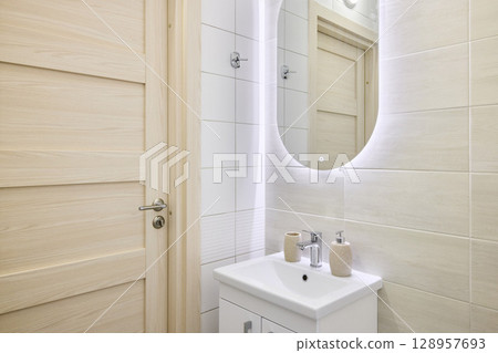 This is a Modern Bathroom featuring a Stylish Sink and an Illuminated Mirror for ambiance This is a Modern Bathroom featuring a Stylish Sink and an Illuminated Mirror for ambiance 128957693