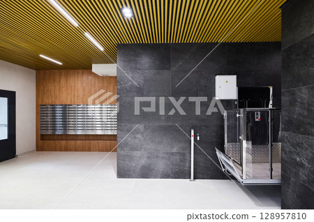 Modern Interior Featuring a Lift and Mailboxes Within a Contemporary Designed Space 128957810
