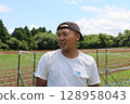 A young male farmer talks under the blue sky in Yachimata, Chiba Prefecture 128958043
