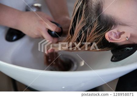 Woman getting shampooed at a beauty salon Woman getting shampooed at a beauty salon 128958071