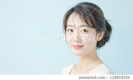 Middle-aged woman with natural make-up on light blue background 128958588