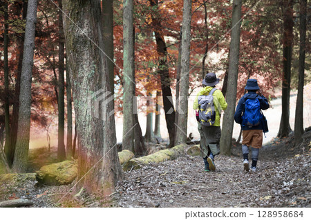 登山者沿著兩旁滿是秋葉的山路行走 128958684