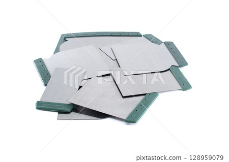 A collection of putty knives with green handles ready for various construction tasks. A collection of putty knives with green handles ready for various construction tasks. 128959079