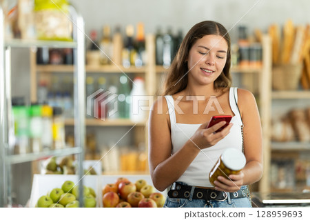Young woman scanning qr code of olives 128959693