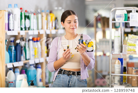 Young woman choosing tools in large household store 128959748