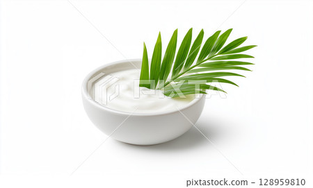 Coconut cream in white ceramic bowl decorated with fresh tropical palm leaf 128959810