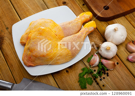 Natural raw chicken leg quarters with seasonings 128960091