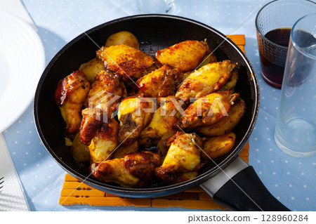fried and served hot chicken wings in pan fried and served hot chicken wings in pan 128960284