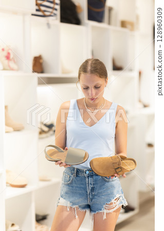 Young woman choosing shoes in a store 128960309