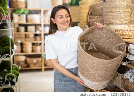 Woman buying wicker basket at hardware store Woman buying wicker basket at hardware store 128960352