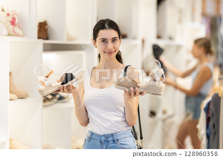 Girl customer choose shoes in branded store Girl customer choose shoes in branded store 128960358