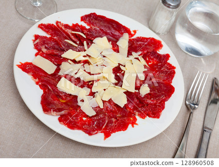 Delicious veal carpaccio served with parmesan cheese 128960508