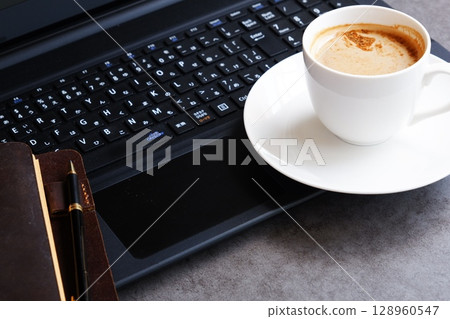 Image of a man working on his laptop while drinking freshly brewed delicious coffee Image of a man working on his laptop while drinking freshly brewed delicious coffee 128960547