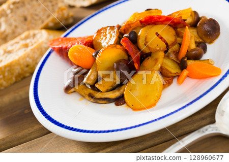 Pan-fried potatoes with mushrooms and chorizo 128960677