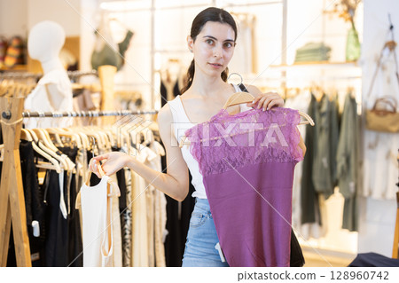 Woman choosing between two blouses 128960742