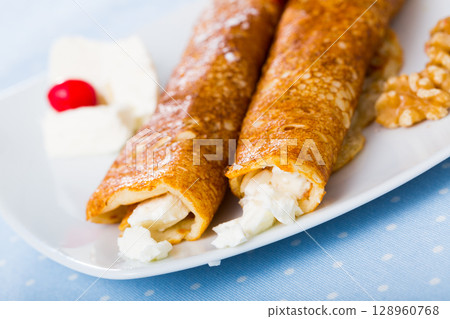 Dish of pancakes palachinki with filling from brynza and walnuts Dish of pancakes palachinki with filling from brynza and walnuts 128960768
