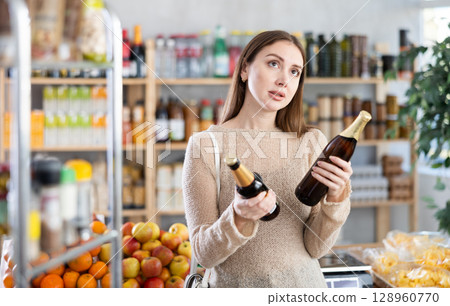 European girl hold bottles package, choose and buy beer in shop European girl hold bottles package, choose and buy beer in shop 128960770