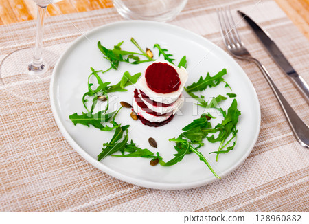 beets with goat cheese and arugula on white plate beets with goat cheese and arugula on white plate 128960882