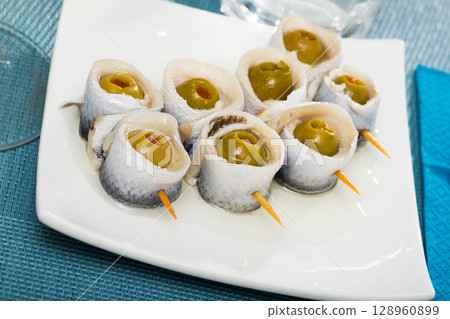 Delicious herring rolls with olives 128960899