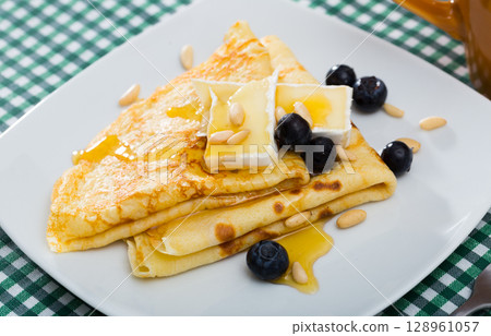 Appetizing pancakes with cheese, honey and nuts Appetizing pancakes with cheese, honey and nuts 128961057