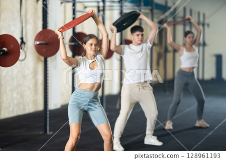 Young woman training with weight plate 128961193