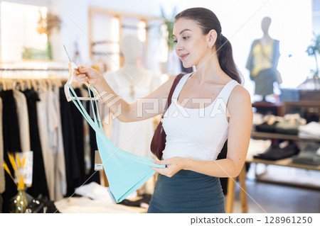 Young woman choosing tank top 128961250